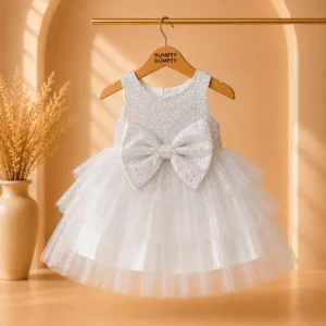 Beautiful white baby girl frock featuring glitter shimmer fabric, layered soft net skirt, and an elegant oversized bow. Perfect for birthdays, weddings, Eid, and special occasions.